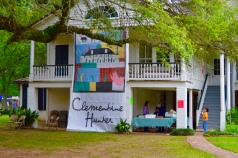A banner on the Big House celebrating the return of the Clementine Hunter paintings after being removed for cleaning and care. Hunter is a famous primitive artist of the Cane River Lake region who used her paintings to depict slave culture.